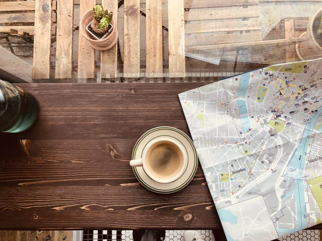 Cup of Coffee on a Saucer Beside a Map