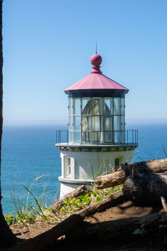 a light house sitting on top of a hill next to the ocean